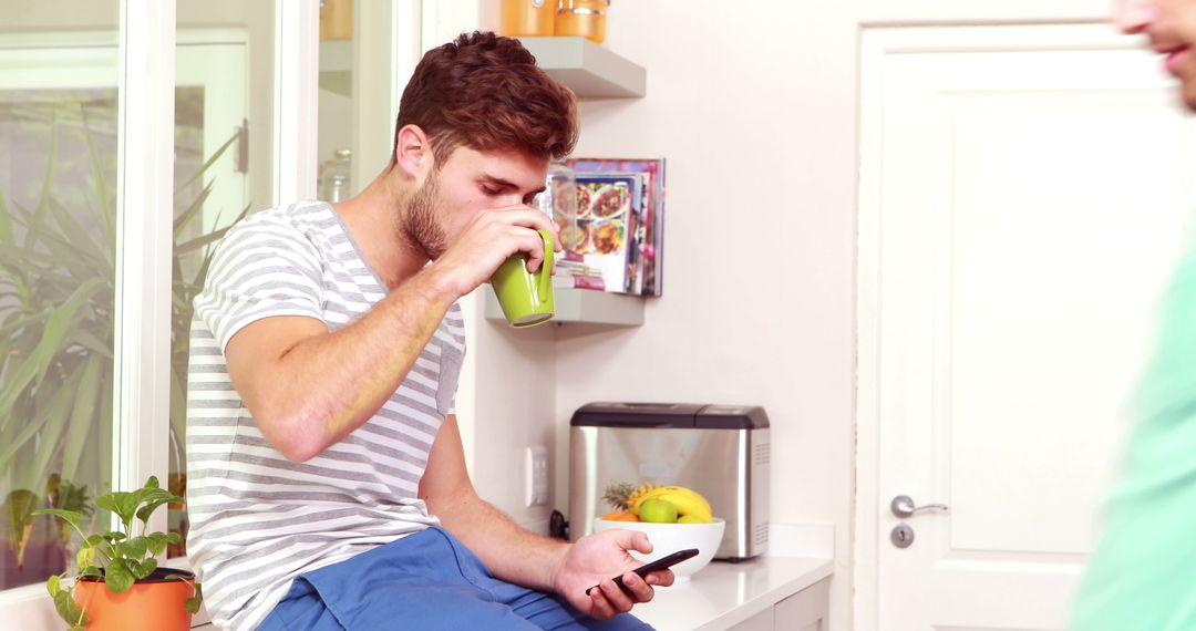 Young Man Drinking Green Smoothie in Modern Kitchen - Free Images, Stock Photos and Pictures on Pikwizard.com