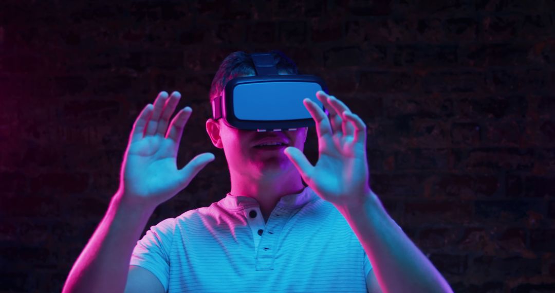 Man Experiencing Virtual Reality with VR Headset in Neon Light - Free Images, Stock Photos and Pictures on Pikwizard.com