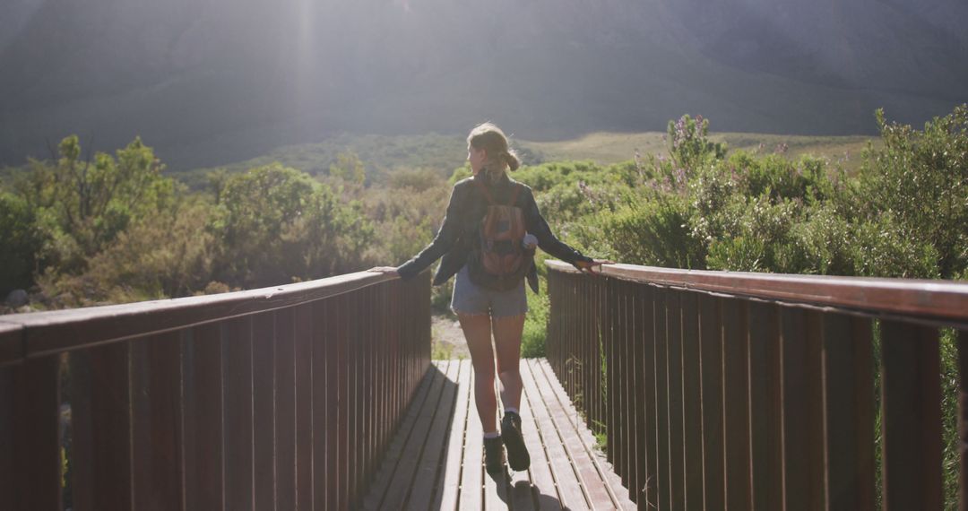 Woman Hiking Across Wooden Bridge in Nature - Free Images, Stock Photos and Pictures on Pikwizard.com