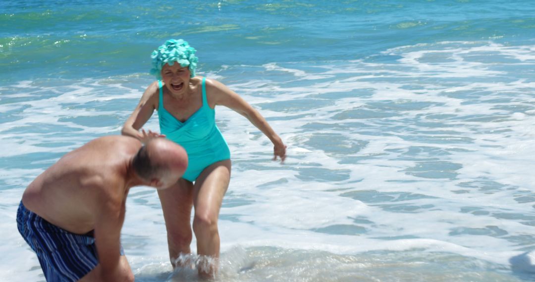 Elderly Couple Enjoying Playful Moments at Beach - Free Images, Stock Photos and Pictures on Pikwizard.com