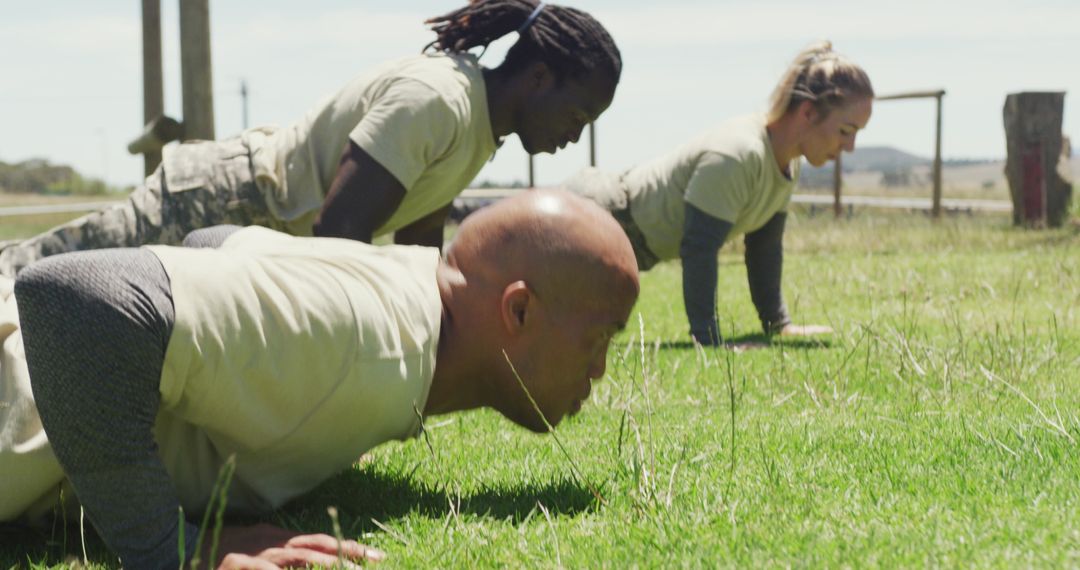 Diverse Soldiers Performing Push-ups Outdoors on Military Obstacle Course