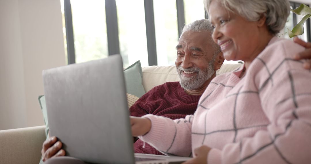 Smiling Senior Couple Engaging with Technology at Home