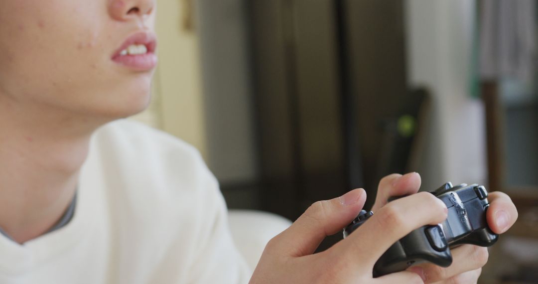 Teenager passionately playing video game with controller - Free Images, Stock Photos and Pictures on Pikwizard.com