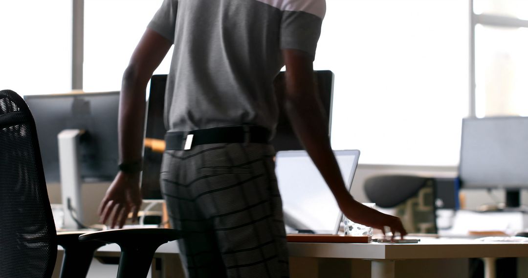 Young Professional Standing at Desk in Modern Office - Free Images, Stock Photos and Pictures on Pikwizard.com