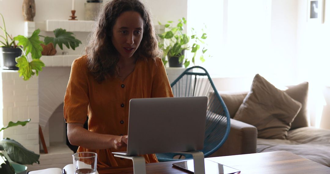 Woman Working on Laptop in Bright Living Room with Modern Decor - Free Images, Stock Photos and Pictures on Pikwizard.com