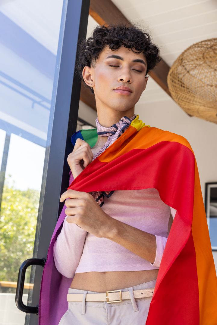 Confident Young Man Draping Rainbow Pride Flag on Patio