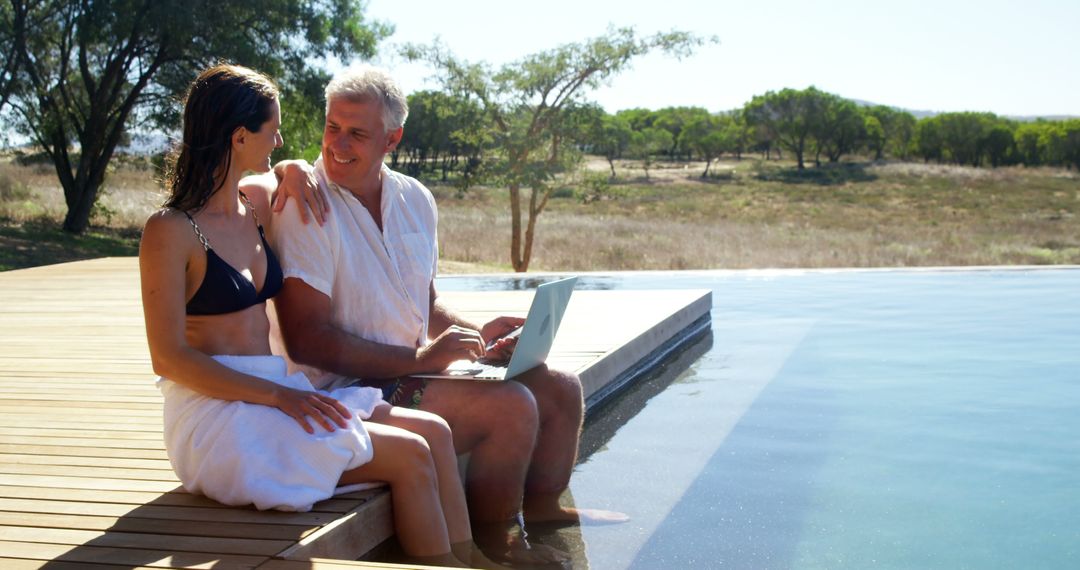 Senior couple relaxing by swimming pool with laptop - Free Images, Stock Photos and Pictures on Pikwizard.com