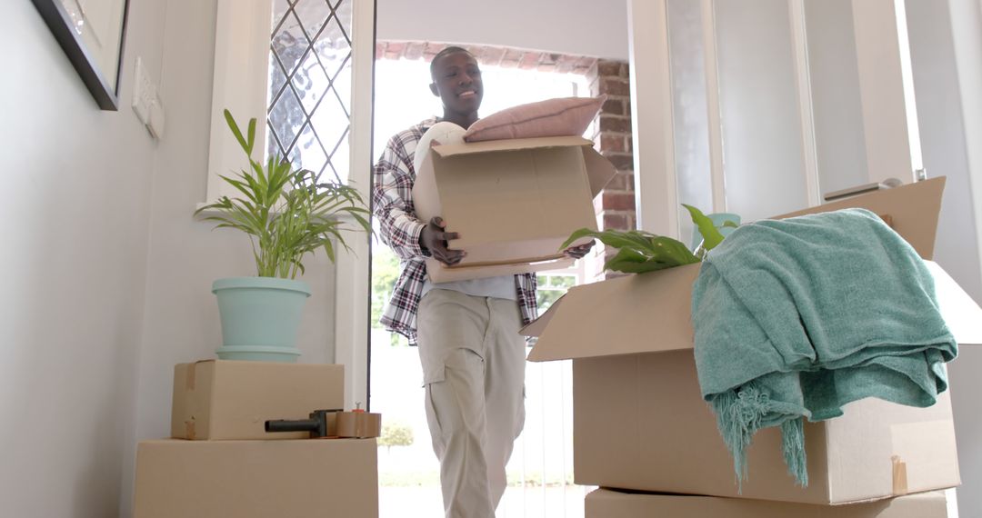 Man Moving into New Home with Boxes and Plant - Free Images, Stock Photos and Pictures on Pikwizard.com