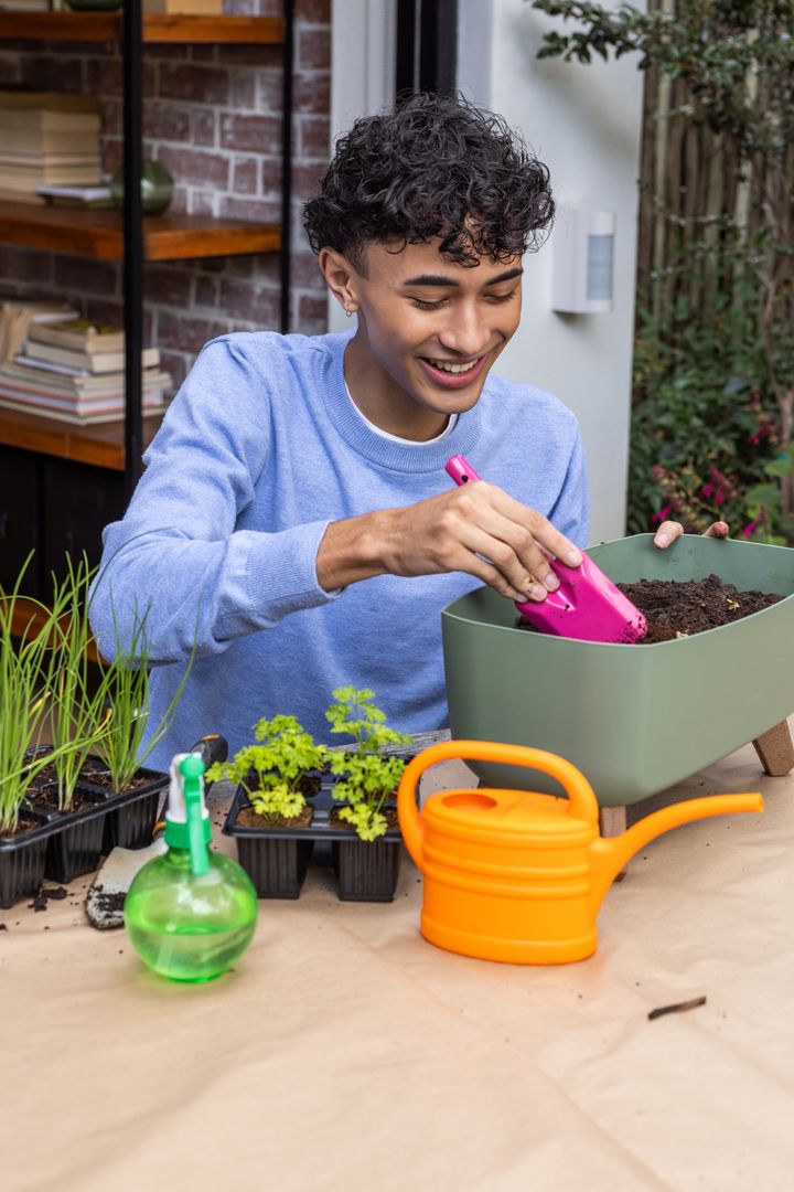 Smiling Man Gardening in Backyard with Seedlings and Tools