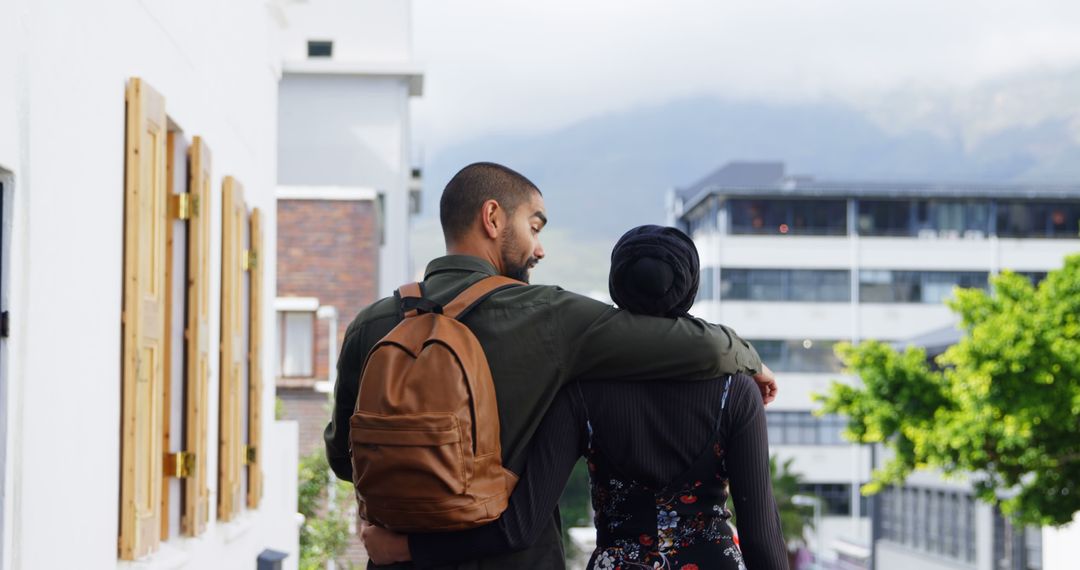 Couple Embracing While Strolling Through City Street