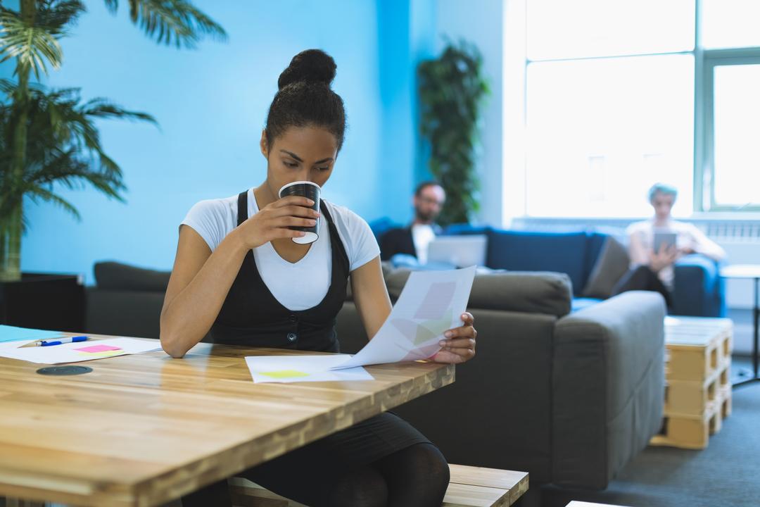 Image of a woman drinking coffee while reading a paper - How social media content creators can benefit from recycling their own content - Image