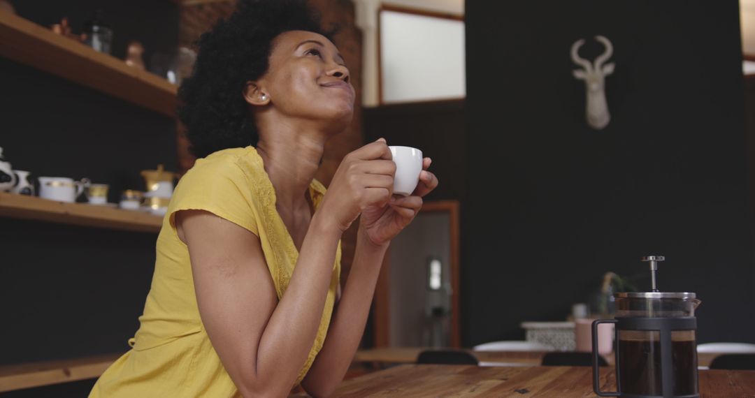 Smiling African American Woman Enjoying Coffee in Modern Kitchen - Free Images, Stock Photos and Pictures on Pikwizard.com