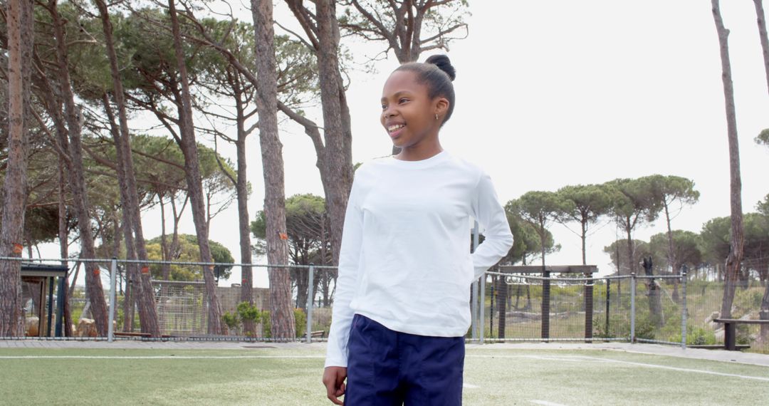 Smiling Girl Enjoying Outdoor Activities on Soccer Field
