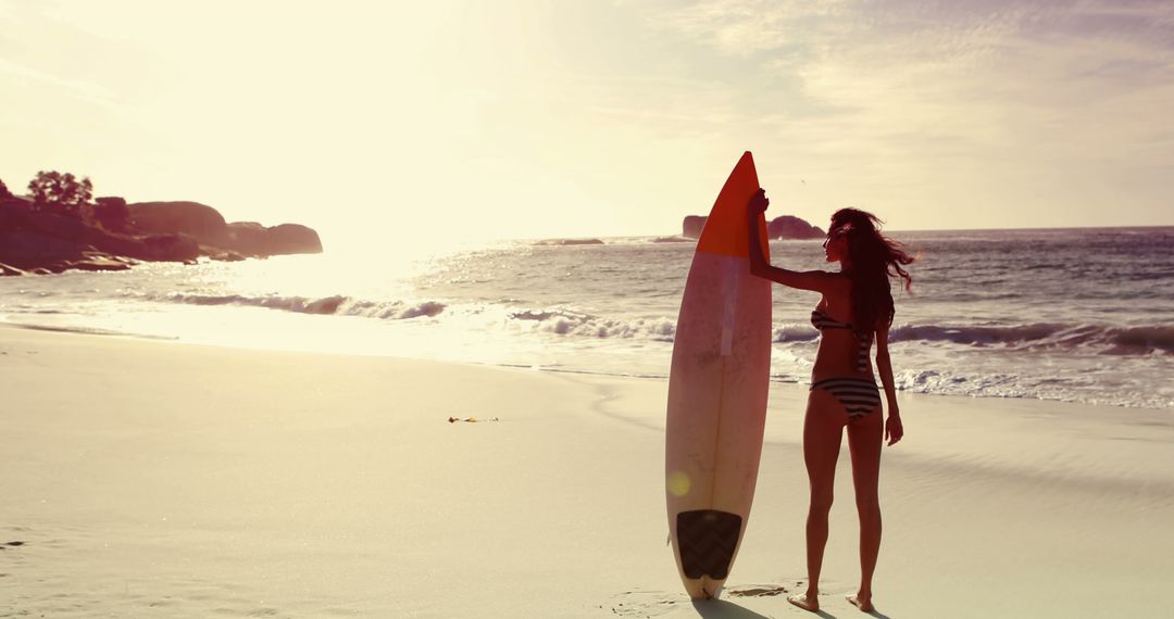 Woman Holding Surfboard on Sandy Beach at Sunset - Free Images, Stock Photos and Pictures on Pikwizard.com