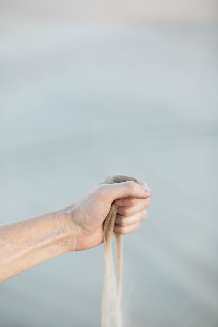 Close-up Hand Releasing Flowing Sand Through Fingers Conceptual Time Passing
