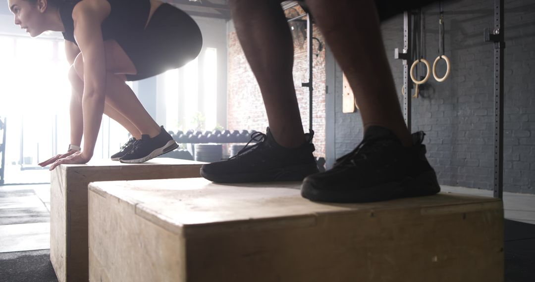 Diverse Partners Executing Plyometric Box Jumps at Gym