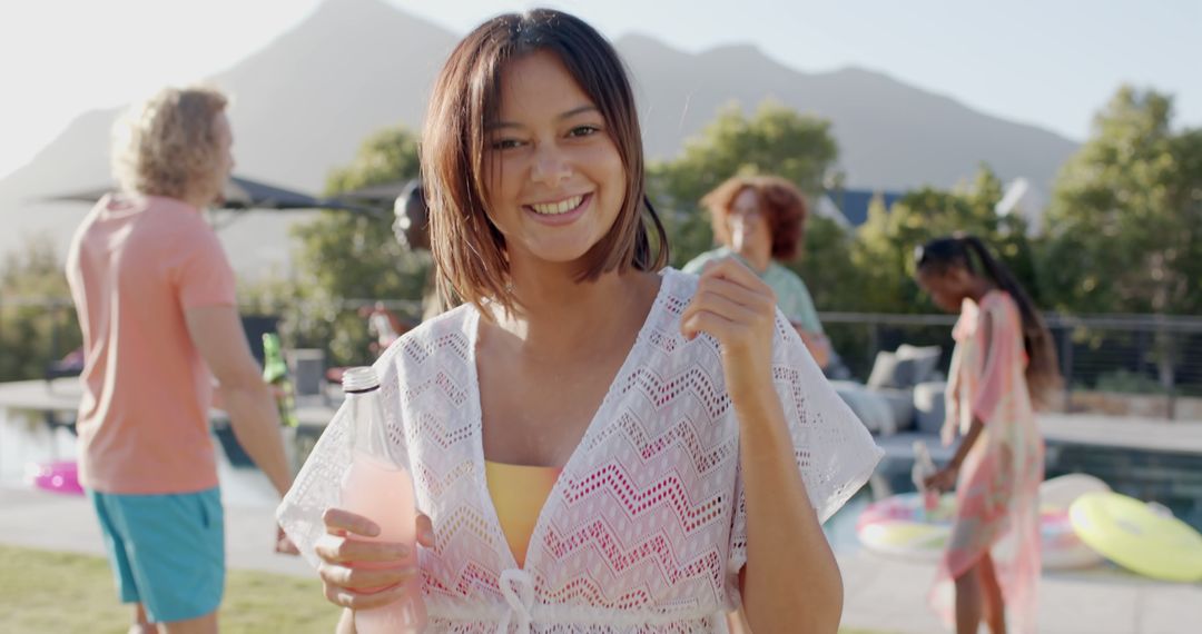 Smiling Woman Holding a Drink at Outdoor Pool Party - Free Images, Stock Photos and Pictures on Pikwizard.com