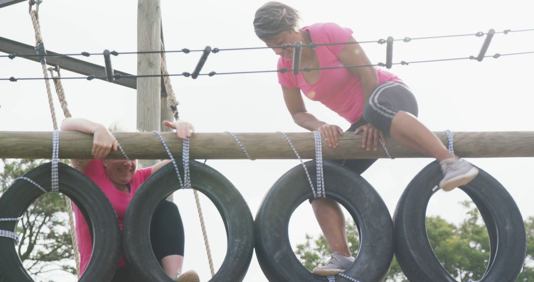 Two Women Tackling Obstacle Course Together with Tire Hurdles - Free Images, Stock Photos and Pictures on Pikwizard.com