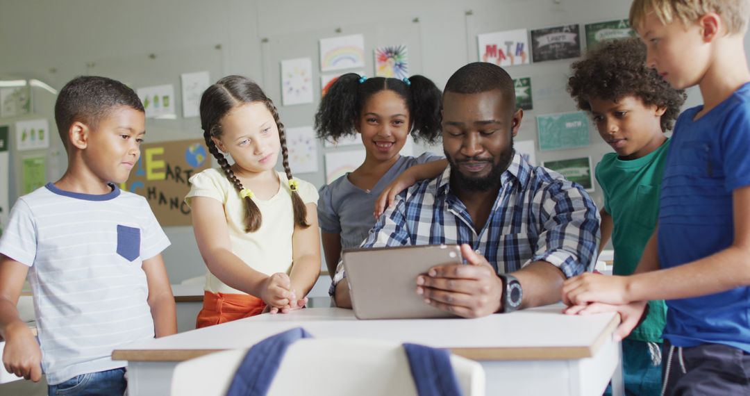 Image of happy african american male teacher and class of diverse pupils working on tablet - Free Images, Stock Photos and Pictures on Pikwizard.com