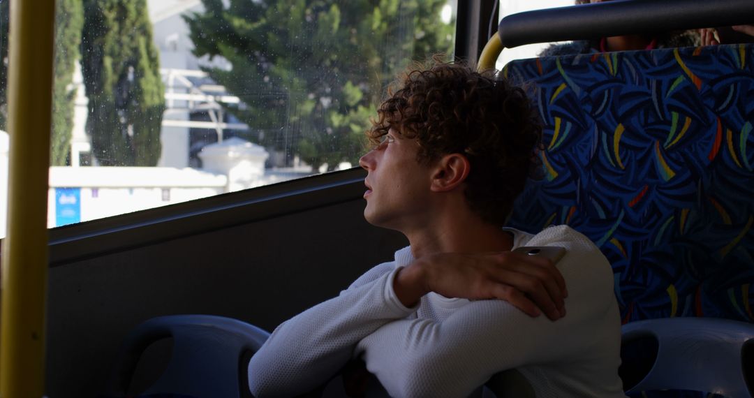 Young Man Reflecting on Bus Journey with Thoughtful Expression - Free Images, Stock Photos and Pictures on Pikwizard.com