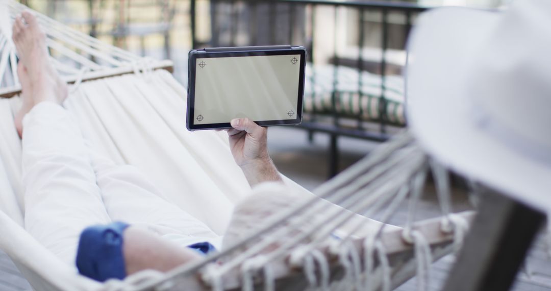 Man Relaxing on Hammock Using Digital Tablet Outdoors - Free Images, Stock Photos and Pictures on Pikwizard.com