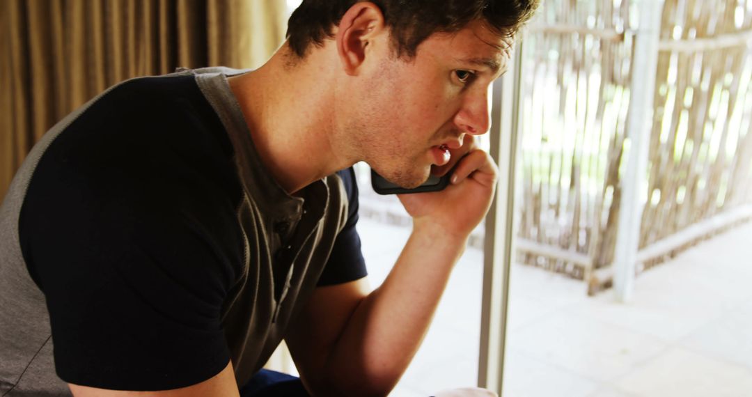 Man Speaking on Smartphone in Relaxed Home Environment