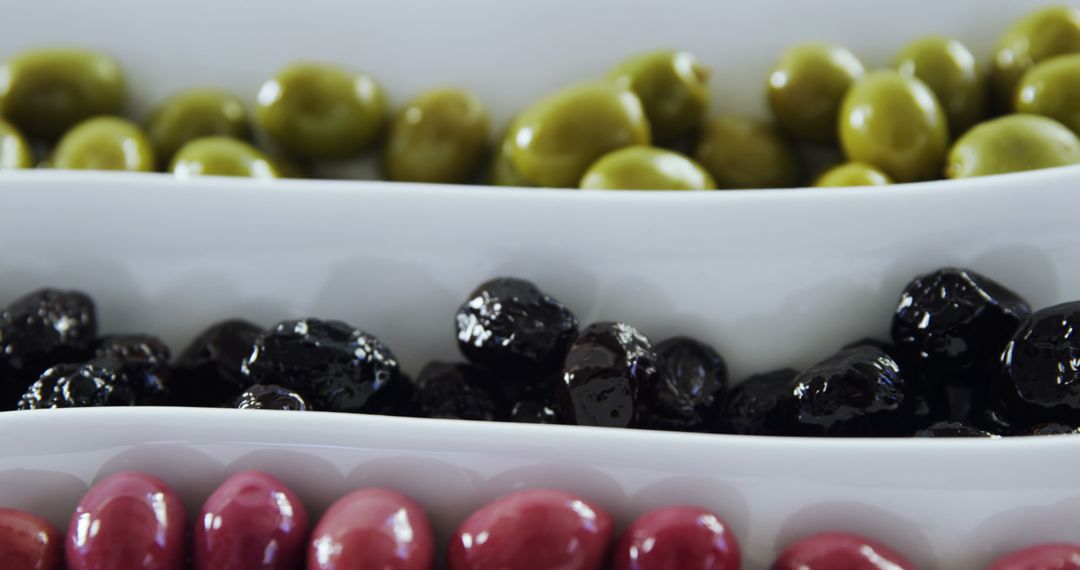 Assortment of Green, Black, and Red Olives in White Ceramic Dishes - Free Images, Stock Photos and Pictures on Pikwizard.com