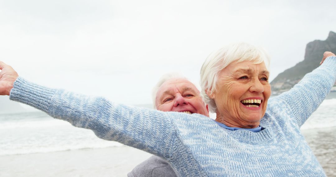 Senior couple enjoying beach vacation with outstretched arms - Free Images, Stock Photos and Pictures on Pikwizard.com