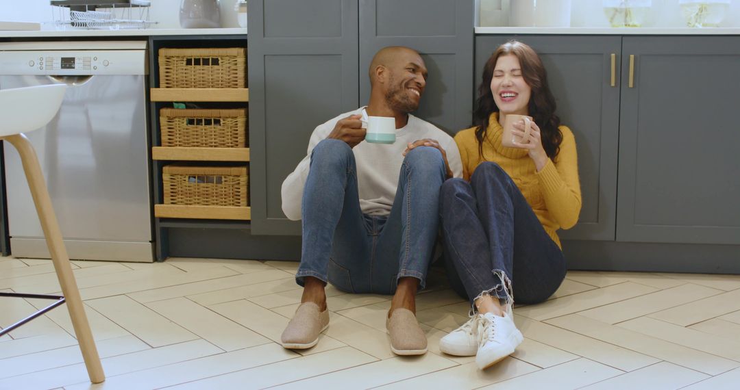 Happy Diverse Couple Relaxing with Coffee in Modern Kitchen