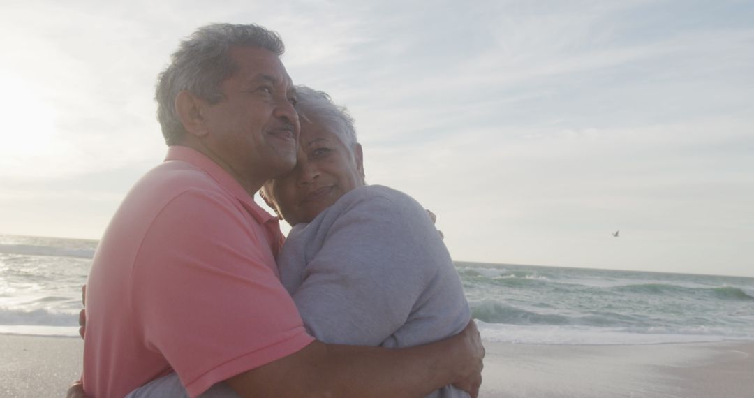 Senior Hispanic Couple Embracing on Tranquil Beach at Sunset