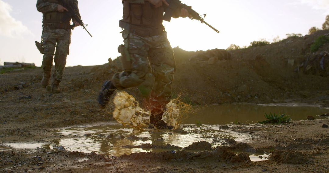 Military Soldiers Running Through Muddy Puddle at Sunset