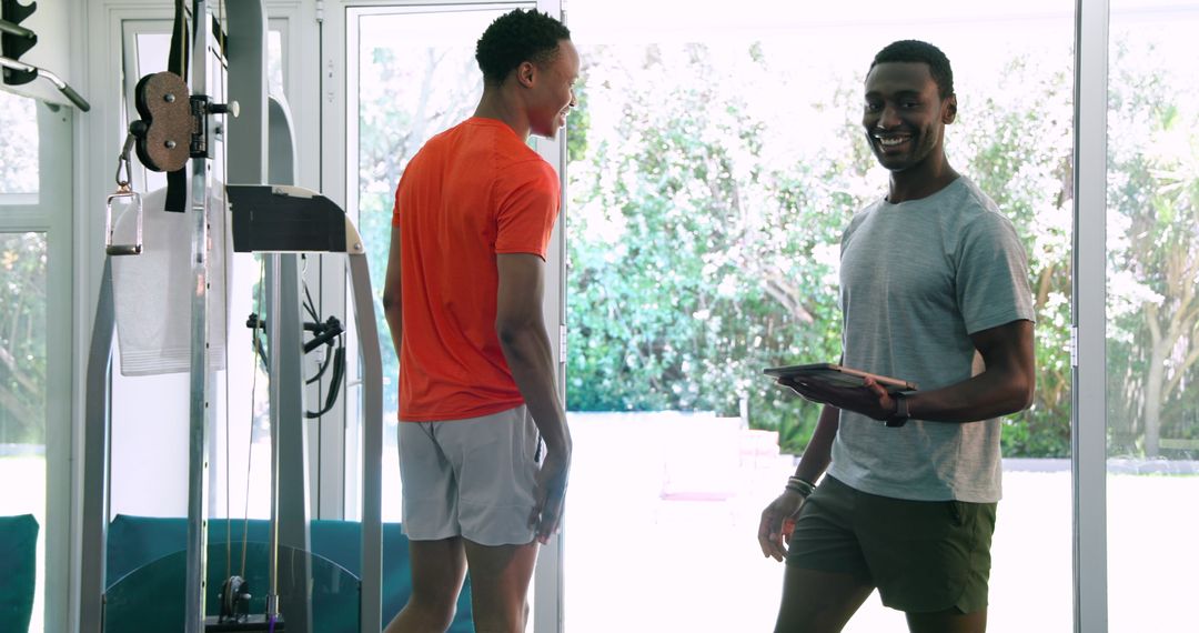 Focused Workout Two Men Exercising on Rowing Machine