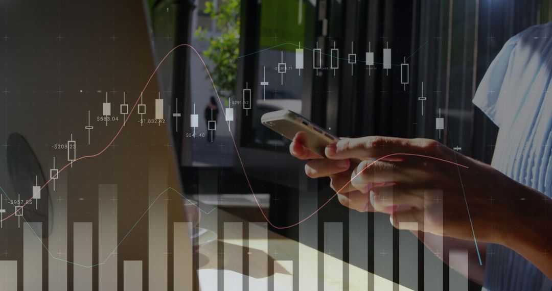 Hands Holding Smartphone Analyzing Financial Data on Laptop