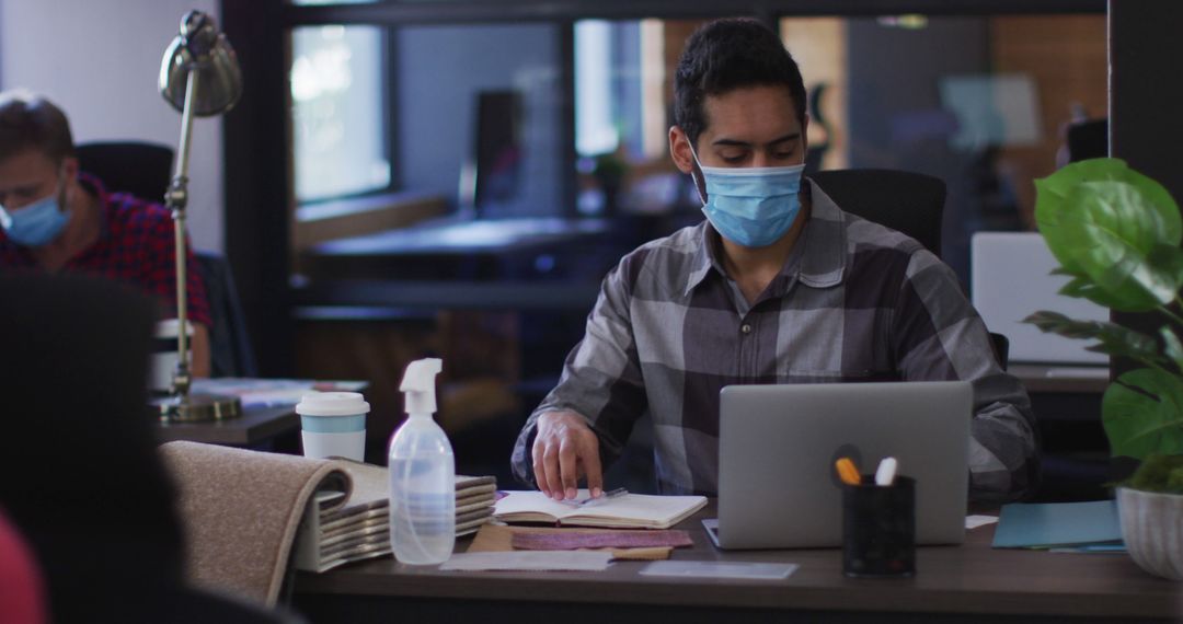 Office Worker Wearing Face Mask Working on Laptop - Free Images, Stock Photos and Pictures on Pikwizard.com