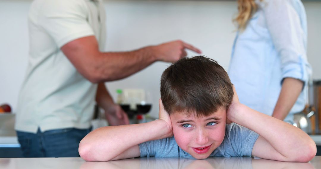 Boy covering ears while parents argue in background - Free Images, Stock Photos and Pictures on Pikwizard.com