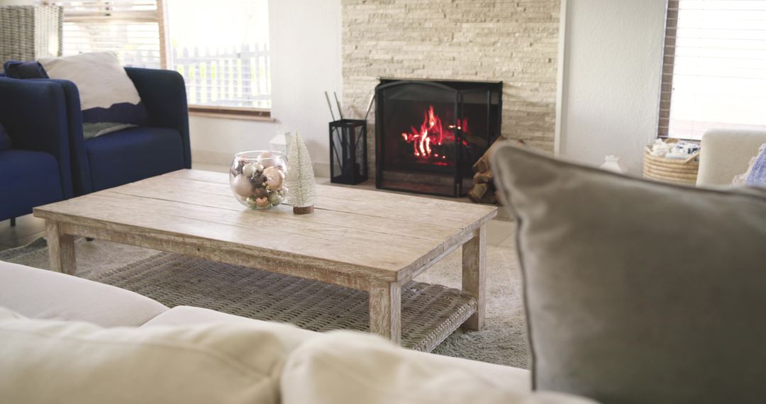 Reclaimed Wood Coffee Table Centered in Cozy Living Room Featuring Lit Fireplace and Ornaments