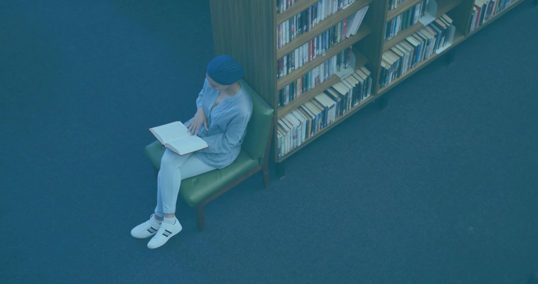 Woman in Library Reading Peacefully Near Bookshelf