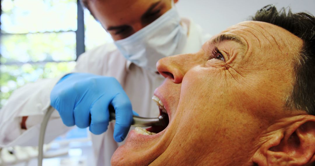 Dentist Treating Senior Patient with Dental Tools - Free Images, Stock Photos and Pictures on Pikwizard.com