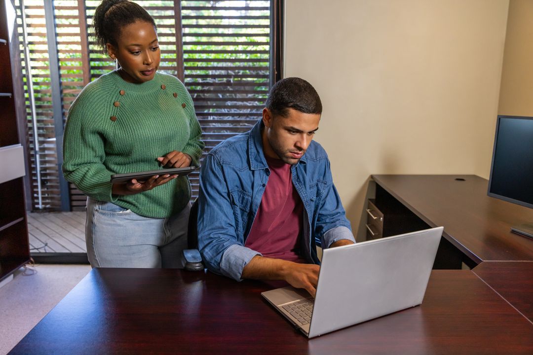 Diverse Team Collaborates in Modern Office with Laptop and Tablet