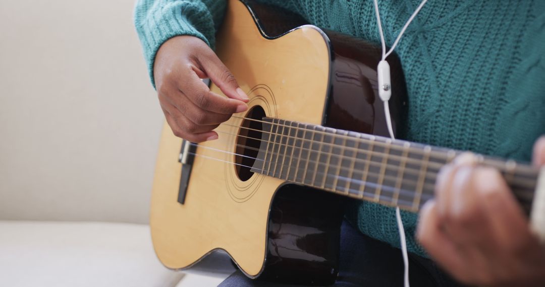 Person Playing Acoustic Guitar and Listening to Music with Earphones - Free Images, Stock Photos and Pictures on Pikwizard.com