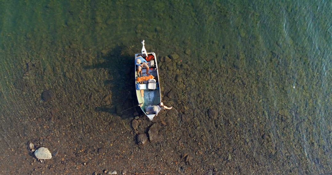 Aerial View of Man Fishing on Boat in Shallow Clear Water - Free Images, Stock Photos and Pictures on Pikwizard.com