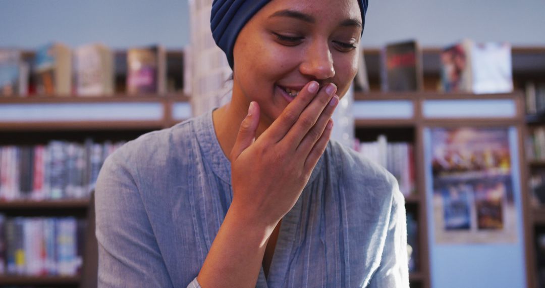 Happy Woman in Library Wearing Blue Headscarf Smiling - Free Images, Stock Photos and Pictures on Pikwizard.com