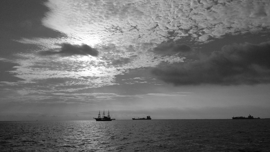 Silhouette of Sailing Ships on Open Sea at Sunset - Free Images, Stock Photos and Pictures on Pikwizard.com