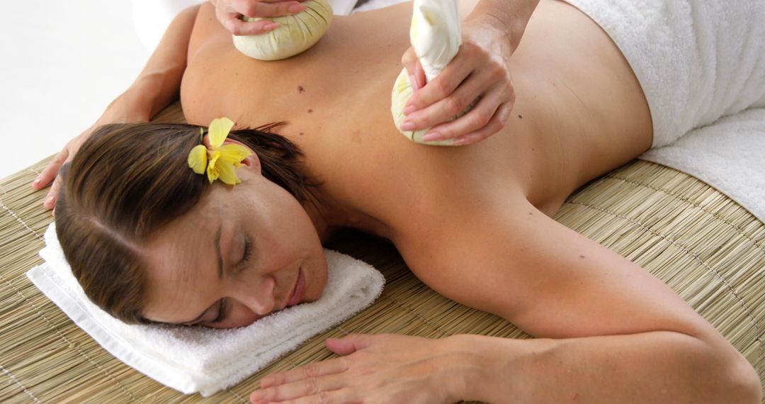 Woman Relaxing During Herbal Massage Therapy Session - Free Images, Stock Photos and Pictures on Pikwizard.com