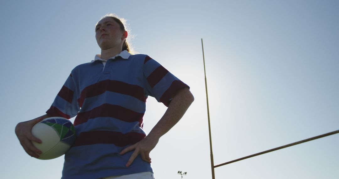 Female Rugby Player Holding Ball at Field with Goalpost - Free Images, Stock Photos and Pictures on Pikwizard.com