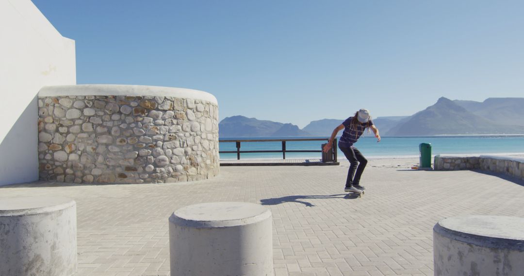 Young man skateboarding by seaside on a beautiful day - Free Images, Stock Photos and Pictures on Pikwizard.com