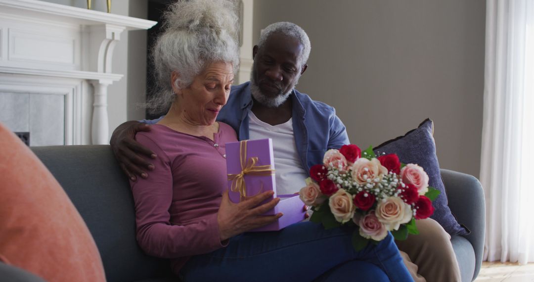 Elderly Couple Exchanging Gift on Sofa, Celebrating Special Occasion Together - Free Images, Stock Photos and Pictures on Pikwizard.com