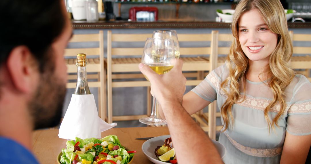 A young Caucasian woman and man are toasting with wine glasses at a dining table, with copy space - Free Images, Stock Photos and Pictures on Pikwizard.com