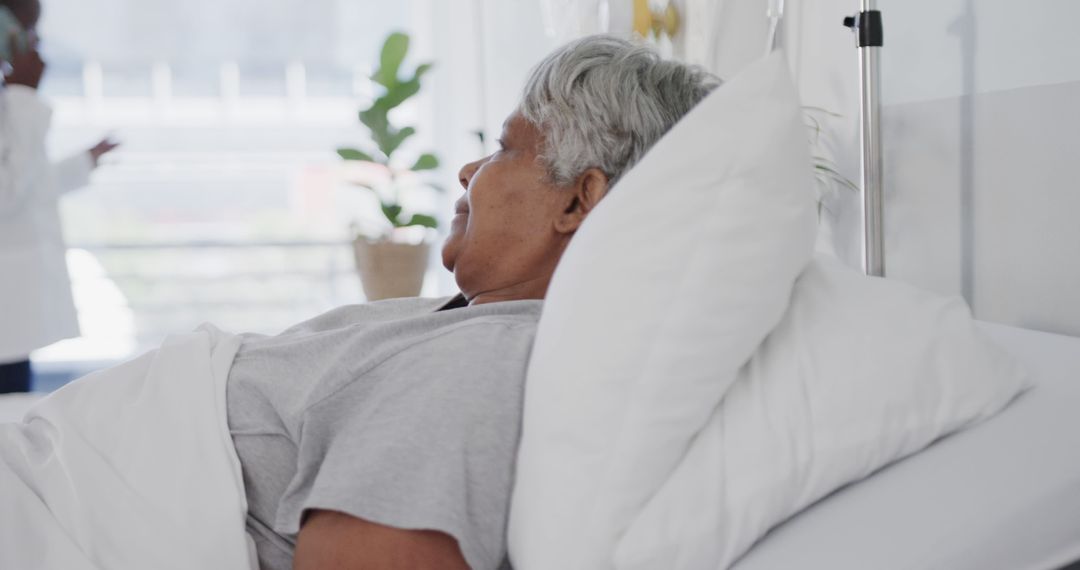 Senior Hospital Patient Resting in Bed with Doctor in Background - Free Images, Stock Photos and Pictures on Pikwizard.com