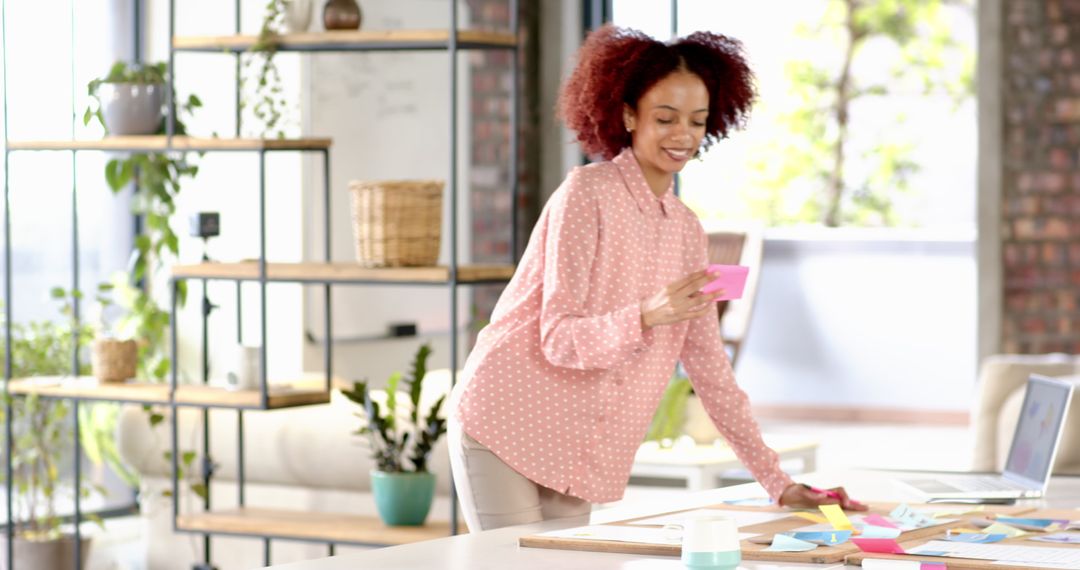 Young Professional Organizing Ideas with Sticky Notes in Creative Office